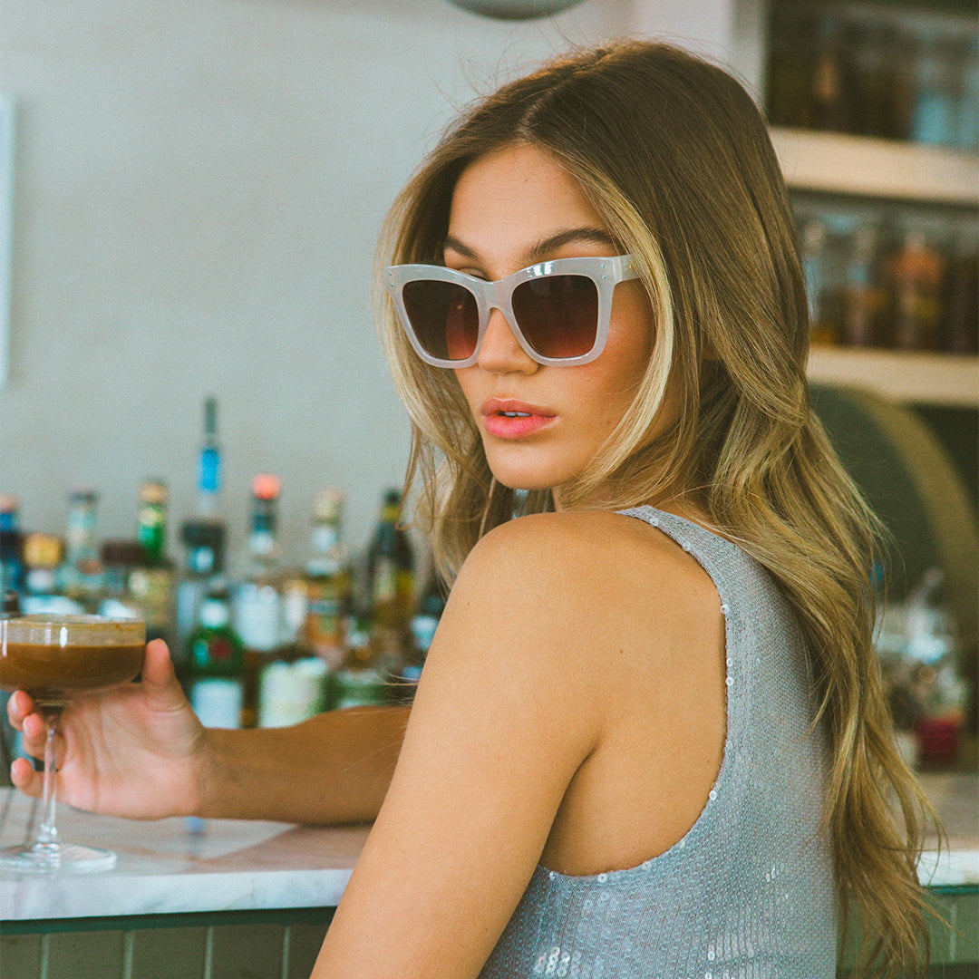 Sunday White Cat Eyes Womens Sunglasses made of polycarbonate and brown lens on model looking sideways