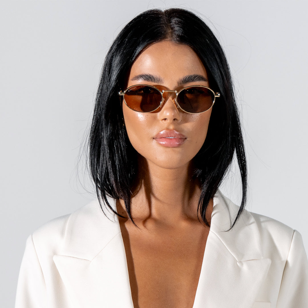 Brooklyn Gold Oval Women's Metal Polarised Sunglasses on model looking towards camera