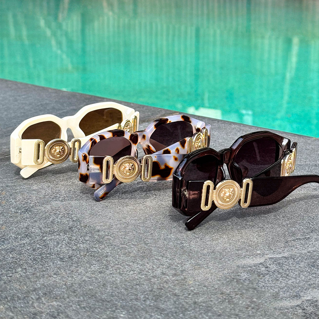 Vogue Angular Women's Sunglasses in different colours laid out next to a pool