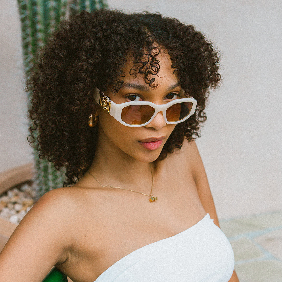 Vogue Cream Angular Womens Sunglasses made of polycarbonate and brown lens on female model looking side on towards the camera